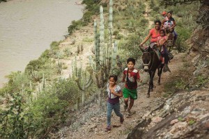 local people walking on cliff beside the maranon river riding donkey